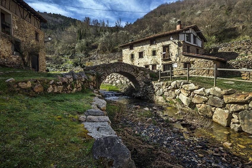 Pueblo de Torrecilla en Cameros con puente de piedra y arroyo