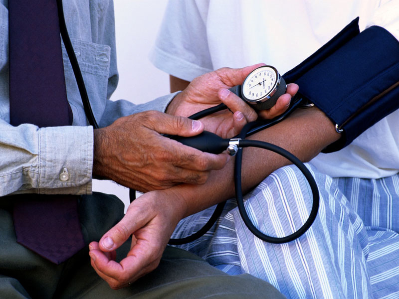 Toma de la tensi&oacute;n arterial con un tensi&oacute;metro de brazalete en una revisi&oacute;n de salud