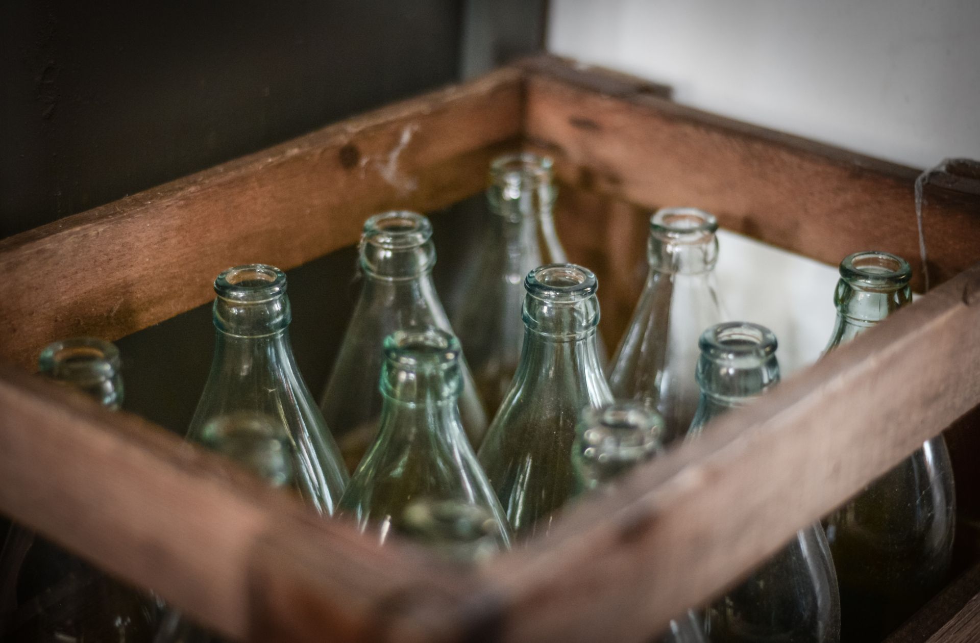 Caja de madera llena de botellas de vidrio vac&iacute;as listas para volver a la planta y ser lavadas y rellenadas