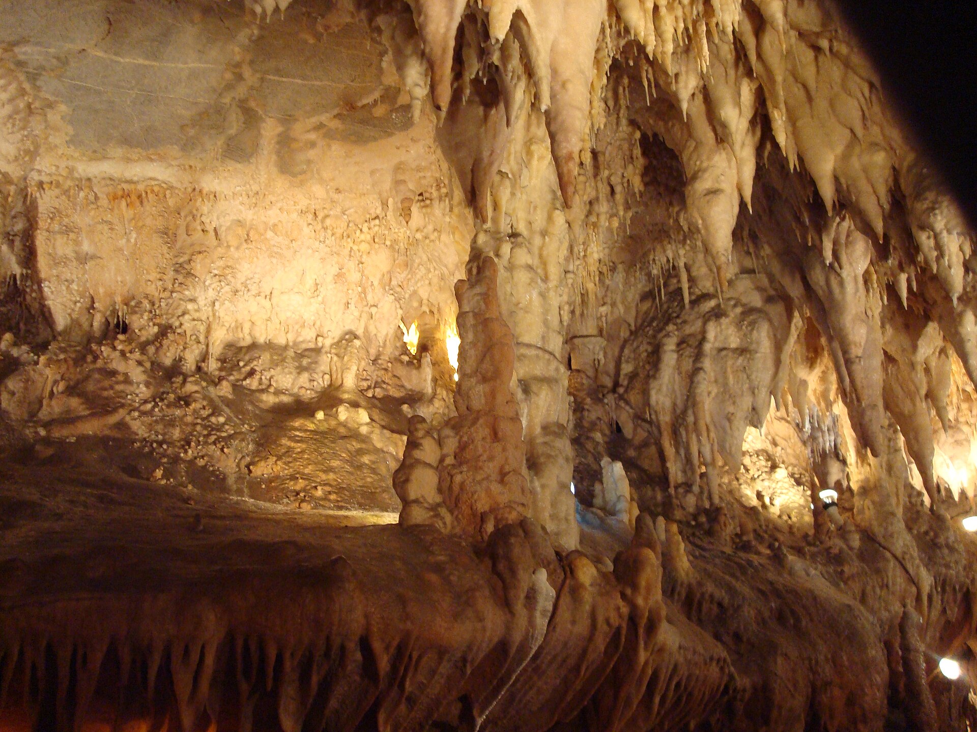 Estalactitas, estalagmitas y columnas de color crema iluminadas dentro de las Cuevas de Ortigosa de Cameros, en La Rioja