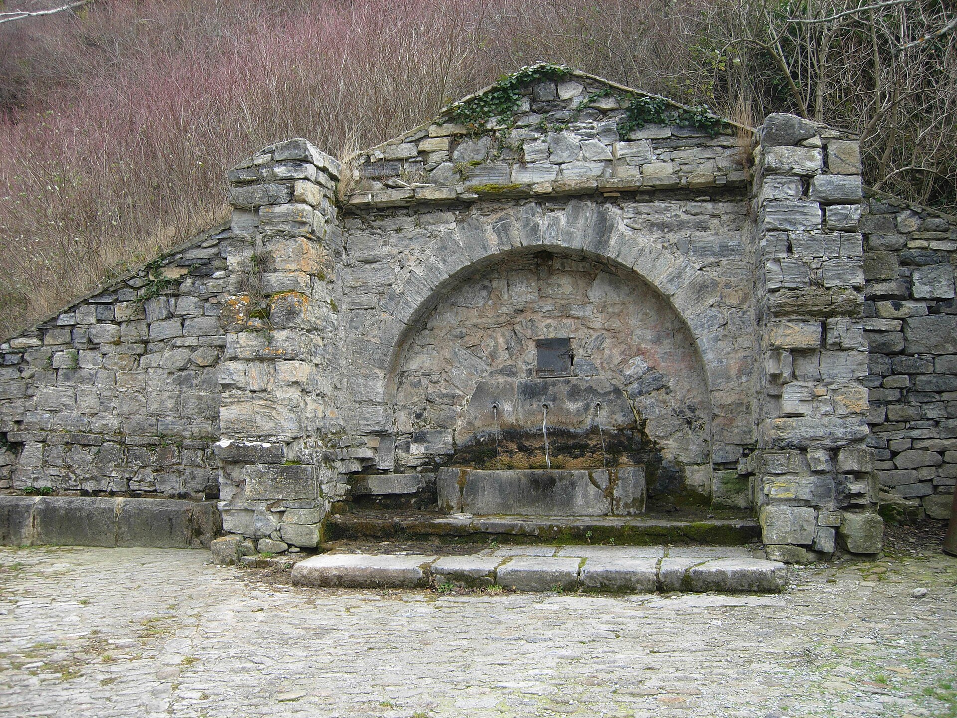 Fuente de los ca&ntilde;os de Soto en Cameros, construcci&oacute;n de piedra con arco y tres ca&ntilde;os de agua corriendo, en la Sierra de Cameros (La Rioja)