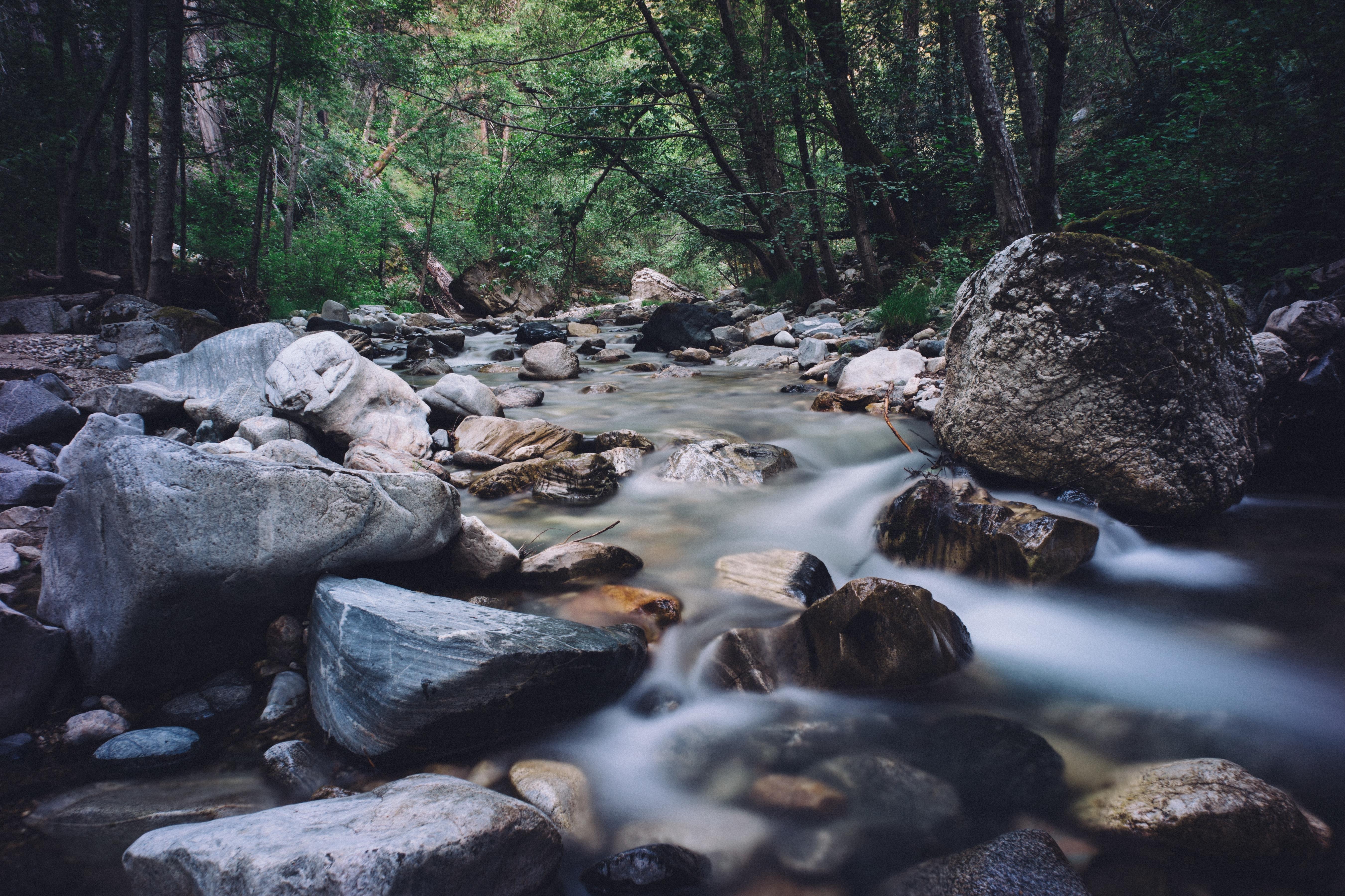 Agua cristalina de un arroyo de monta&ntilde;a fluyendo sobre rocas, donde el agua disuelve el silicio de la piedra
