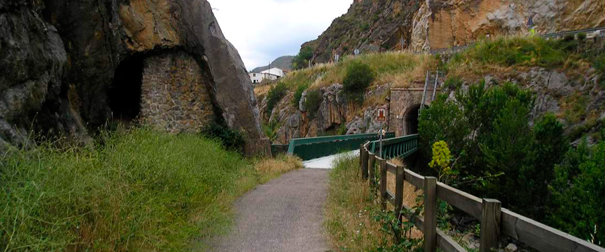 Sendero de la V&iacute;a Verde del Cidacos siguiendo el valle del r&iacute;o entre laderas de roca y vegetaci&oacute;n de ribera en La Rioja
